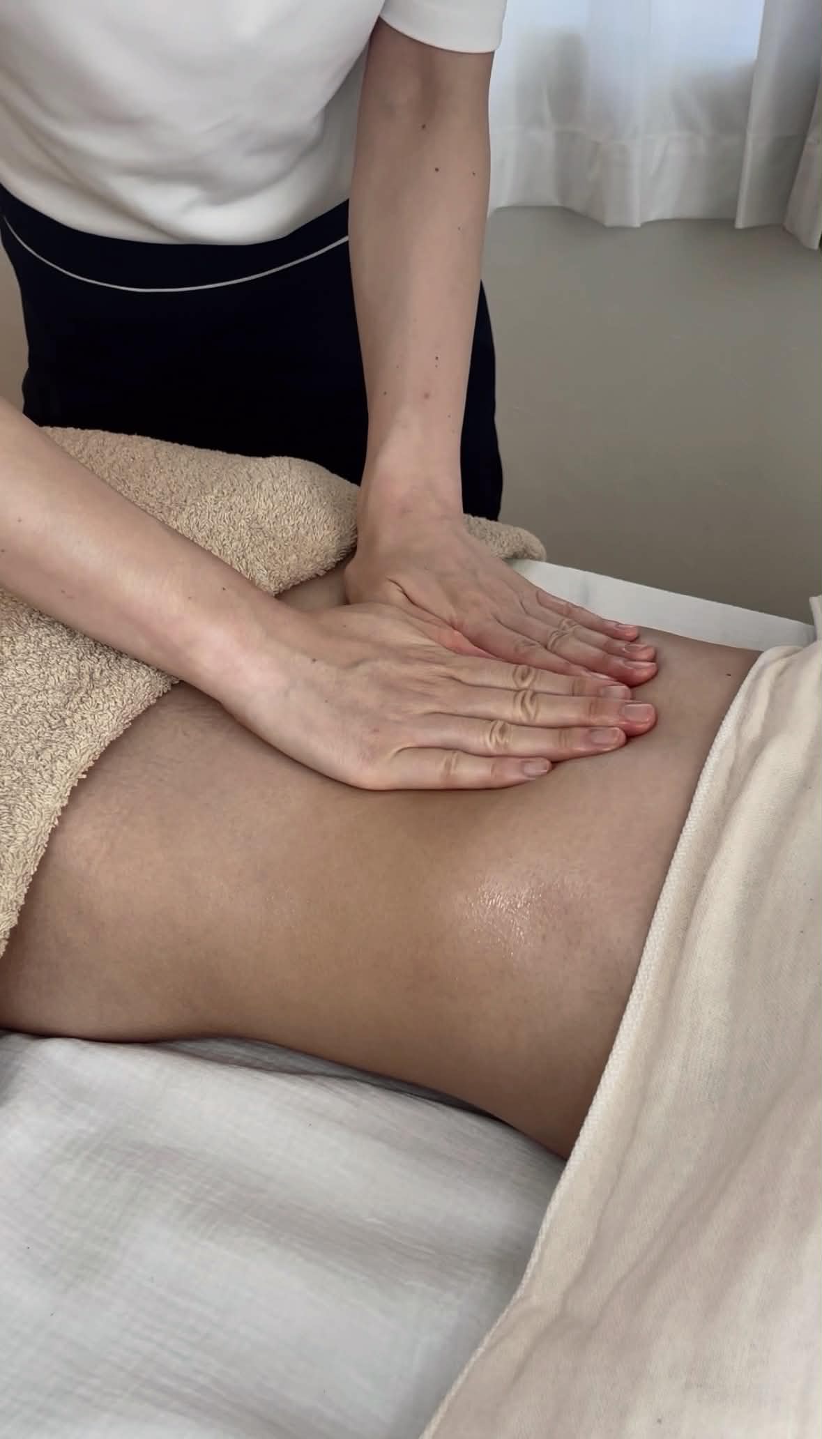 手のひらを使ってお腹をやさしくケアする腸セラピーの様子